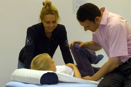 Osteopath treating a child with mum present